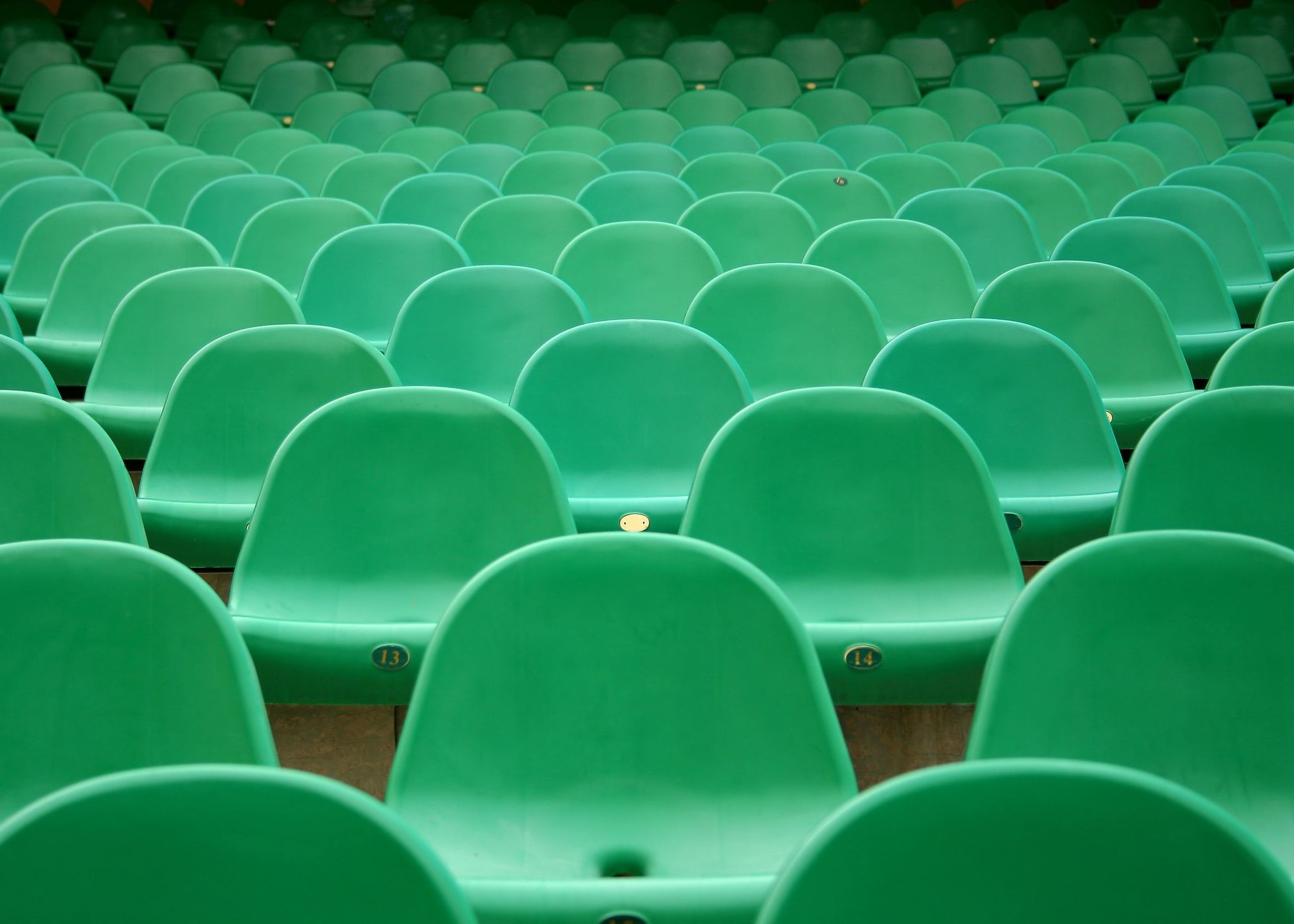 Empty green chairs in an auditorium for Target Audience page